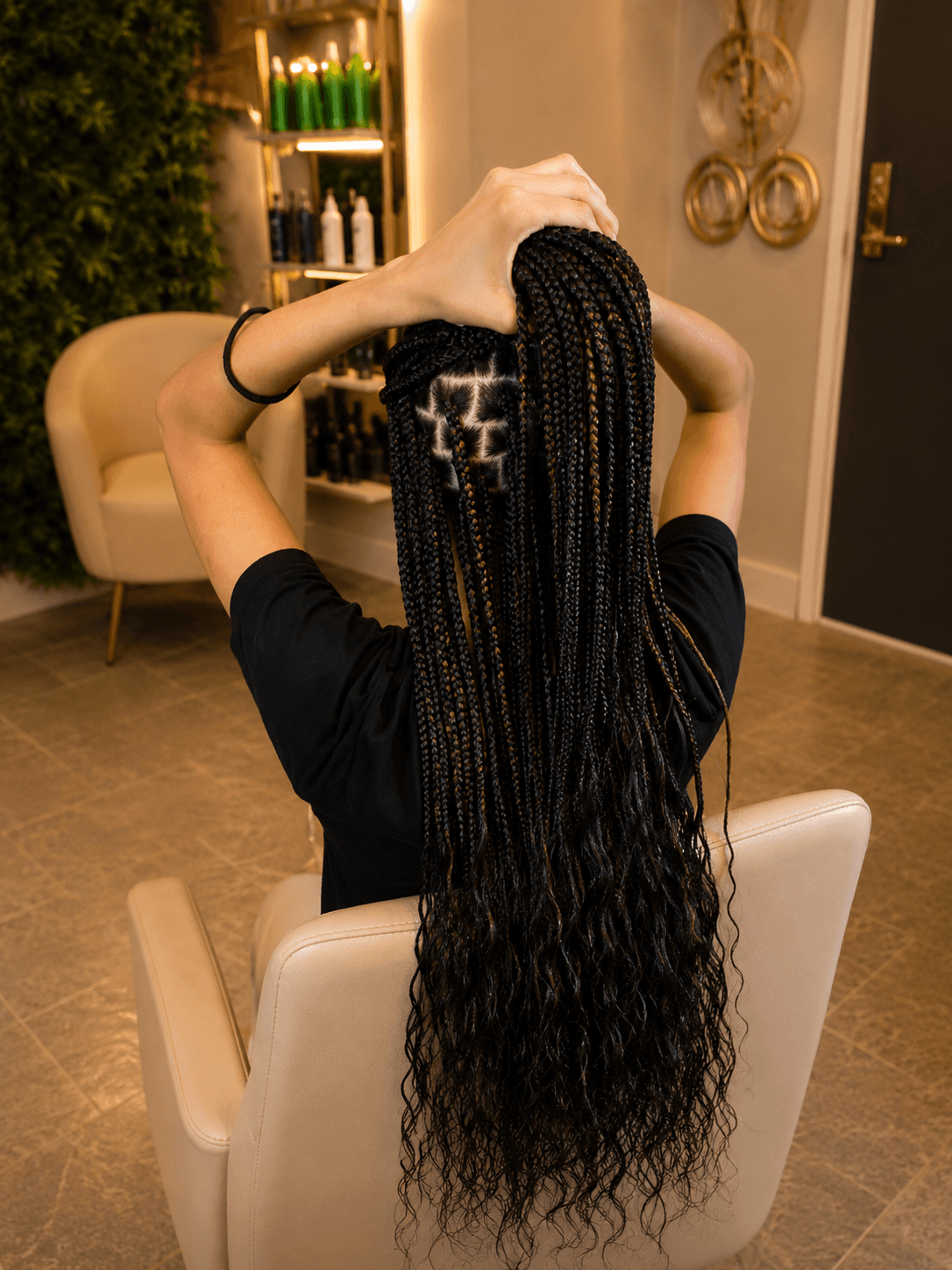 Long black knotless braids with wavy ends held up — hip length back view
